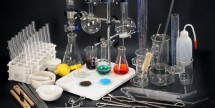Zestaw szkła laboratoryjnego ze sprzętem uzupełniającym do prowadzenia ćwiczeń i doświadczeń w szkolnej pracowni chemicznej.